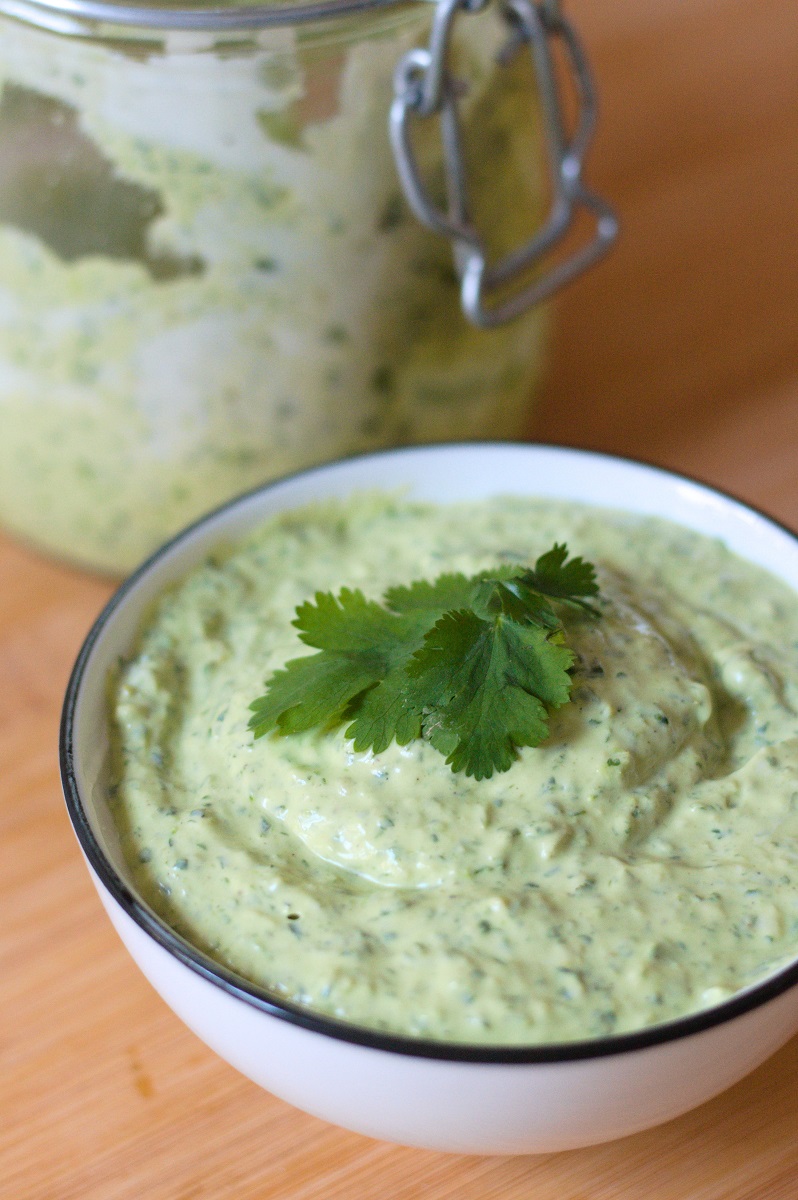 Cilantro lime sauce with jalapeño and avocado in white bowl. 